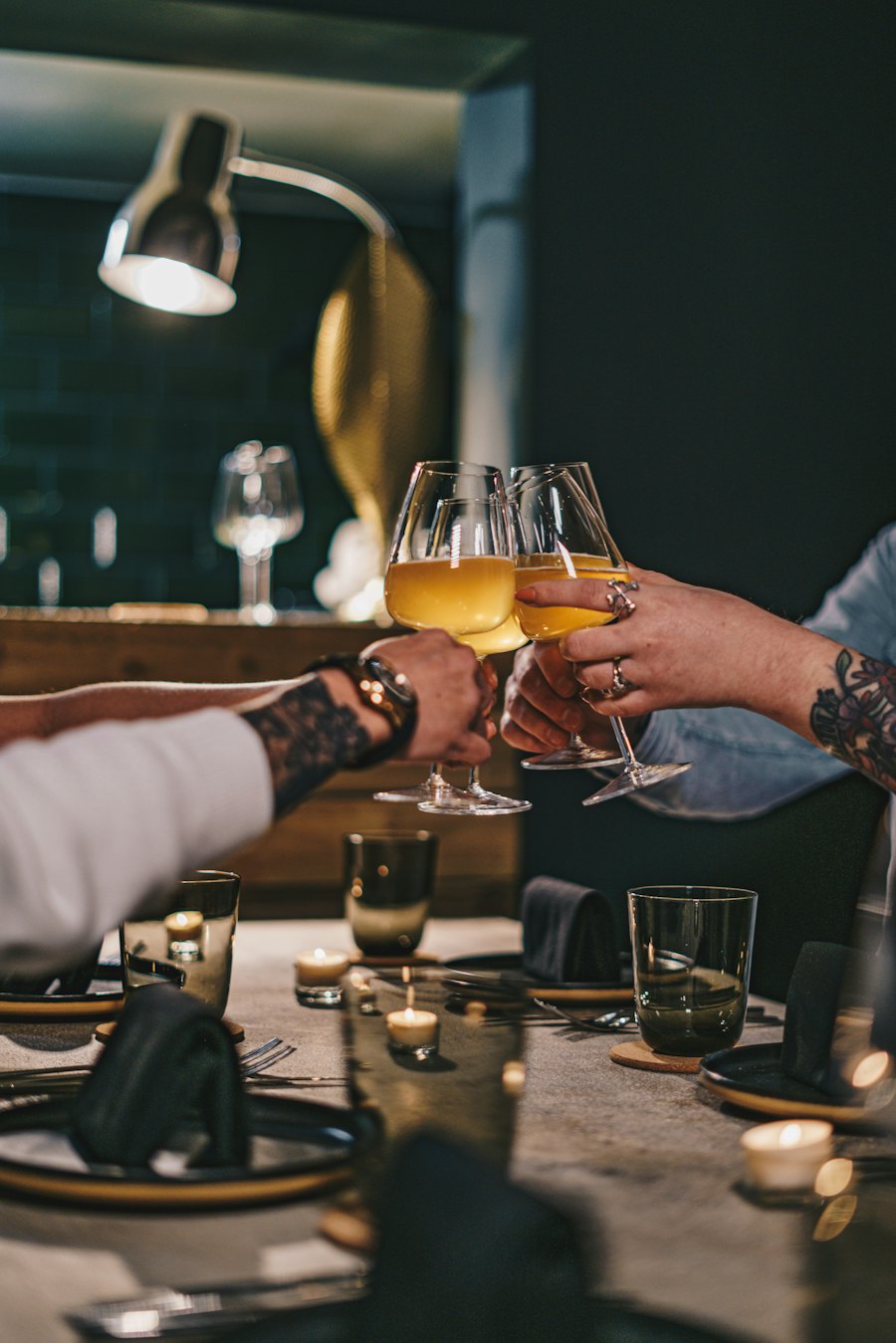 Two people raising glasses over a candlelit table