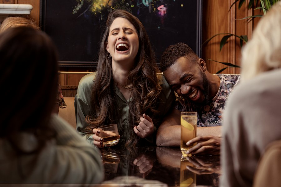 Two people laughing at a restaurant table